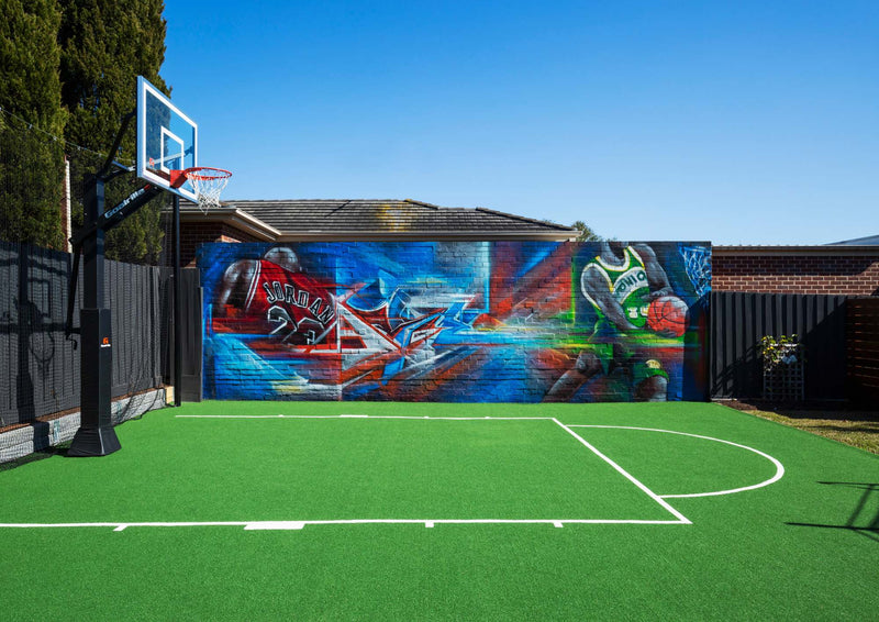 Outdoor synthetic basketball court with vibrant player mural and adjustable hoop, Melbourne