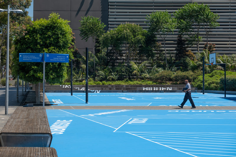 Outdoor acrylic multi-sport court with blue basketball and netball lines at Monash University campus