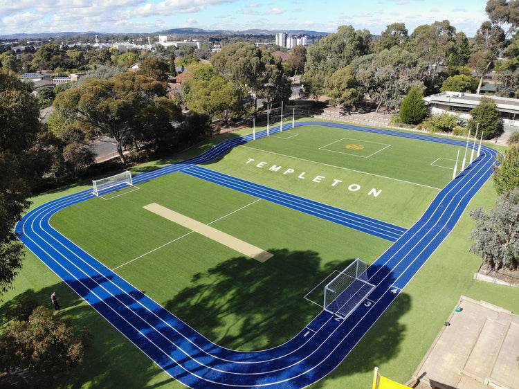 Aerial view of synthetic turf sports field with blue running track at Templeton school